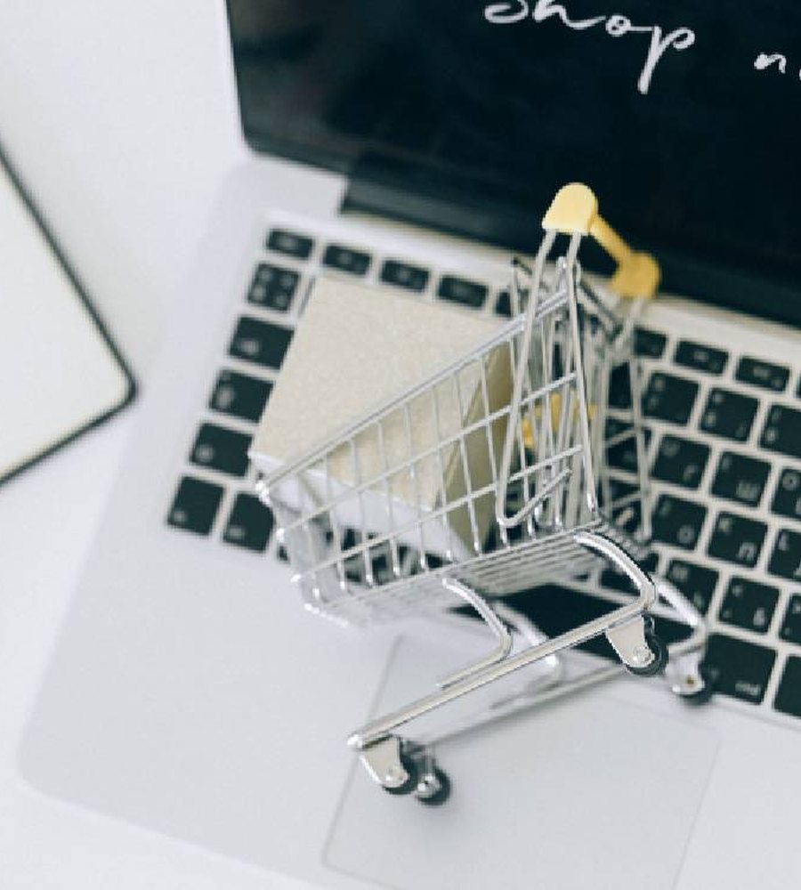 Miniature shopping cart on a laptop keyboard